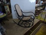 a rocking chair in a room with a rug on the floor