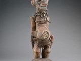 a wooden statue of a man holding a guitar