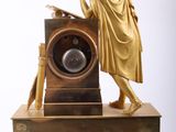 a statue of a man holding a clock on top of a table