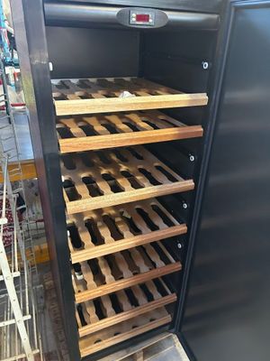 a refrigerator that has a bunch of bottles of wine in it