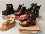 three pairs of boots are sitting on top of boxes on a table