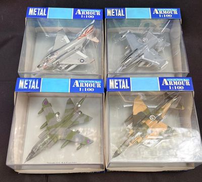 quatre maquettes d'avions en plastique sont rangées dans des boîtes posées sur une surface noire