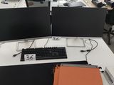 deux écrans d'ordinateur et un clavier posés sur le bureau