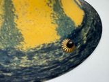 a yellow and blue vase with a flower on it