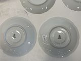 several plates and bowls sitting on a table with a person standing next to them