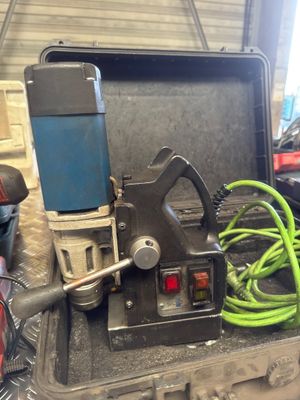 a tool that is sitting in a case with a green hose