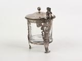 a glass jar with a silver lid on a white surface
