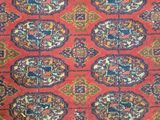 a close up of a red rug with a pattern on it