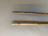 two wooden sticks sitting on top of a table next to each other