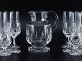 four wine glasses and a pitcher on a table