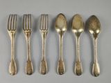six fourchettes et cuillères sont alignées sur une table