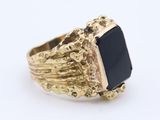 an image of a gold ring with a black stone on it