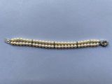 un bracelet de perles blanches avec un fermoir en argent