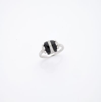 une image représentant une bague noire et blanche posée sur une surface blanche