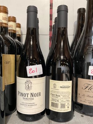 plusieurs bouteilles de vin sont alignées sur une étagère dans un magasin