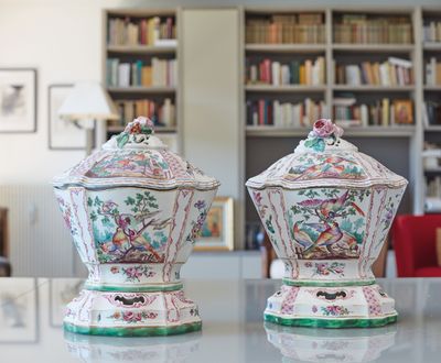 deux vases posés sur une table devant une bibliothèque