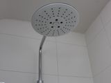a shower head in a bathroom with a white tiled wall