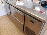 plan de travail en acier inoxydable dans une cuisine professionnelle où le plan de travail est encombré