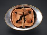 a metal bowl with a baseball glove and a bat in it