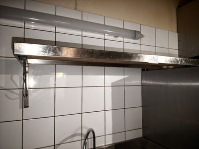 une étagère métallique au-dessus d'un évier de cuisine