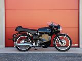 a black motorcycle parked in front of a red garage door