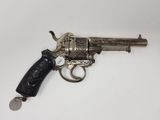 un vieux revolver argenté avec une crosse noire sur un fond blanc