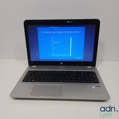 a laptop computer sitting on a table with a blue screen