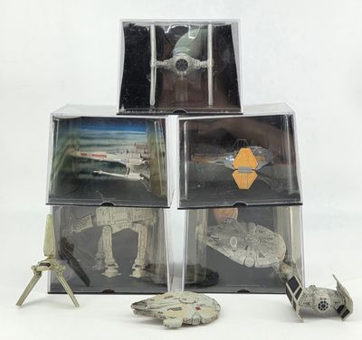 trois figurines de Star Wars sont posées sur une pile de cartons