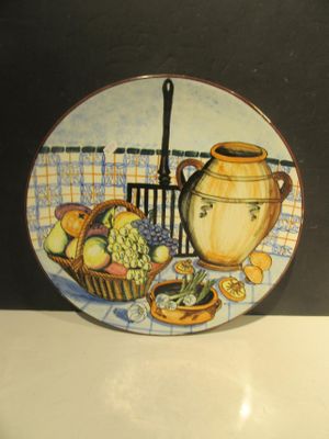 une assiette sur laquelle est représenté un pot et une corbeille de fruits