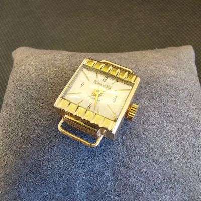 une montre en or posée sur un oreiller bleu
