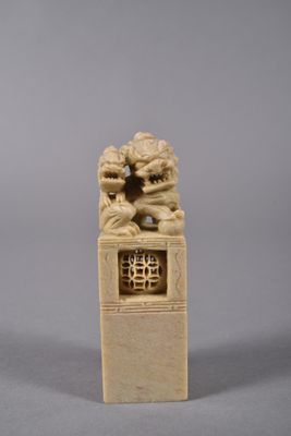 two carved ivory figurines of two lions on a pedestal