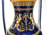 a blue and gold vase sitting on a white surface