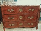 une commode en bois avec un plateau en marbre dans une chambre