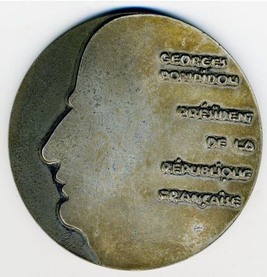 une médaille d'argent sur laquelle est représenté le visage d'un homme