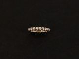 a white gold ring with three rows of diamonds on a black background