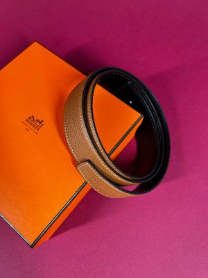 a close up of a belt on a pink surface with a box