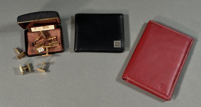 un portefeuille rouge, des boutons de manchette et une paire de boutons de manchette posés sur une table