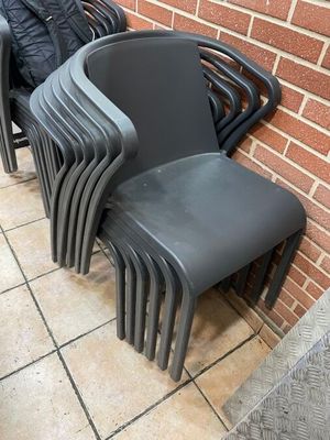 a lot of chairs that are lined up against a brick wall