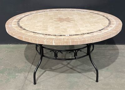 une table ronde avec un plateau en carrelage et un piètement en métal