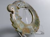 a green sculpture of a fish on a clear stand