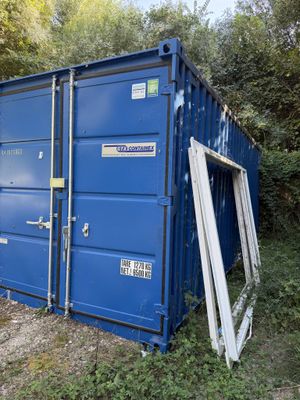 a blue container sitting in the middle of a field