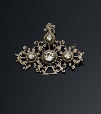 une broche ancienne en argent et diamants posée sur un fond noir