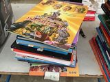 beaucoup de livres posés sur une table, avec une télévision en arrière-plan
