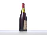 a bottle of wine sitting on top of a table next to a bottle of wine