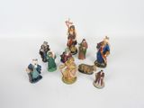 many figurines of people that are sitting on a white surface