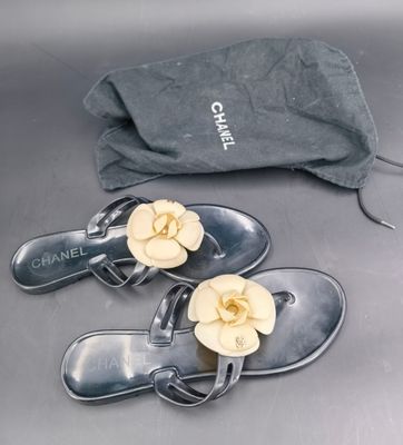 une paire de sandales Chanel et un sac posés sur une table