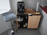 a small kitchen with a coffee maker and a bar stool