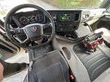 a view of the inside of a truck with a steering wheel and dashboard