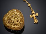 a close up of a gold necklace with a cross on it