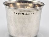 an antique silver cup with a star design on the side